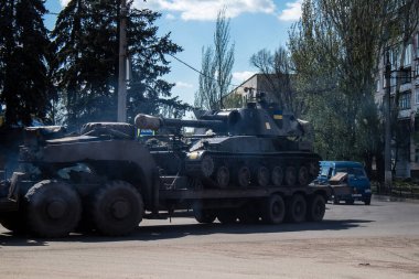 Sloviansk, Ukrayna - 26 Nisan 2023 Ukraynalı bir ordu kamyonu kendi kendine itilen bir havan topu, tekerlekli bir topçu sistemi taşıyor. Bunlar yüksek derecede hareket kabiliyetine sahipler ve bu da çekilen havan toplarına karşı başlıca avantajları.. 