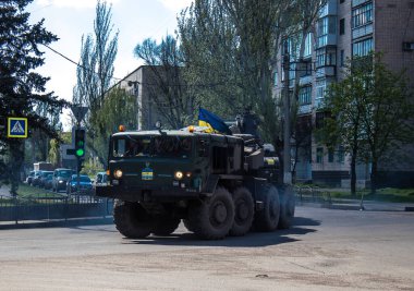 Sloviansk, Ukrayna - 26 Nisan 2023 Ukraynalı bir ordu kamyonu kendi kendine itilen bir havan topu, tekerlekli bir topçu sistemi taşıyor. Bunlar yüksek derecede hareket kabiliyetine sahipler ve bu da çekilen havan toplarına karşı başlıca avantajları.. 