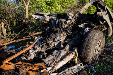 Ukraynalı askerler, Bakhmut yakınlarındaki bir ormanın kenarındaki savaş bölgesinde top atışları sonucu hasar gören bir arabayı yüklüyorlar. Askerler tekrar kullanılabilmesi için aracın motorunu kurtarmayı planlıyorlar..