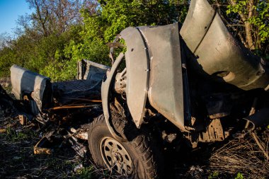 Ukraynalı askerler, Bakhmut yakınlarındaki bir ormanın kenarındaki savaş bölgesinde top atışları sonucu hasar gören bir arabayı yüklüyorlar. Askerler tekrar kullanılabilmesi için aracın motorunu kurtarmayı planlıyorlar..