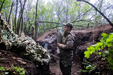 28. Topçu Taburu 'ndan Ukraynalı asker Bakhmut yakınlarındaki ormanın sıfır noktasında bir Rus hedefine 120 mm' lik havan topu atıyor. Rus ve Ukrayna orduları Donbass 'ta çarpışıyor, çatışma yoğun ve savaş şiddetleniyor. Bir...