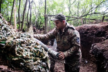28. Topçu Taburu 'ndan Ukraynalı asker Bakhmut yakınlarındaki ormanın sıfır noktasında bir Rus hedefine 120 mm' lik havan topu atıyor. Rus ve Ukrayna orduları Donbass 'ta çarpışıyor, çatışma yoğun ve savaş şiddetleniyor. Bir...