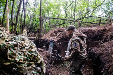28. Topçu Taburu 'ndan Ukraynalı asker Bakhmut yakınlarındaki ormanın sıfır noktasında bir Rus hedefine 120 mm' lik havan topu atıyor. Rus ve Ukrayna orduları Donbass 'ta çarpışıyor, çatışma yoğun ve savaş şiddetleniyor. Bir...