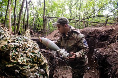 28. Topçu Taburu 'ndan Ukraynalı asker Bakhmut yakınlarındaki ormanın sıfır noktasında bir Rus hedefine 120 mm' lik havan topu atıyor. Rus ve Ukrayna orduları Donbass 'ta çarpışıyor, çatışma yoğun ve savaş şiddetleniyor. Bir...