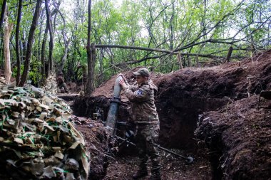 28. Topçu Taburu 'ndan Ukraynalı asker Bakhmut yakınlarındaki ormanın sıfır noktasında bir Rus hedefine 120 mm' lik havan topu atıyor. Rus ve Ukrayna orduları Donbass 'ta çarpışıyor, çatışma yoğun ve savaş şiddetleniyor. Bir...