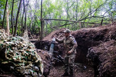 28. Topçu Taburu 'ndan Ukraynalı asker Bakhmut yakınlarındaki ormanın sıfır noktasında bir Rus hedefine 120 mm' lik havan topu atıyor. Rus ve Ukrayna orduları Donbass 'ta çarpışıyor, çatışma yoğun ve savaş şiddetleniyor. Bir...