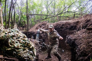 28. Topçu Taburu 'ndan Ukraynalı asker Bakhmut yakınlarındaki ormanın sıfır noktasında bir Rus hedefine 120 mm' lik havan topu atıyor. Rus ve Ukrayna orduları Donbass 'ta çarpışıyor, çatışma yoğun ve savaş şiddetleniyor. Bir...