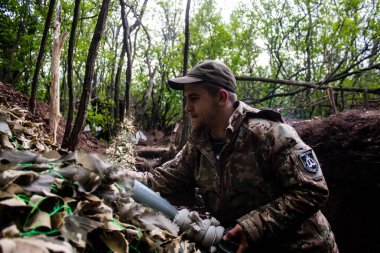 28. Topçu Taburu 'ndan Ukraynalı asker Bakhmut yakınlarındaki ormanın sıfır noktasında bir Rus hedefine 120 mm' lik havan topu atıyor. Rus ve Ukrayna orduları Donbass 'ta çarpışıyor, çatışma yoğun ve savaş şiddetleniyor. Bir...