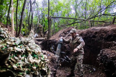 28. Topçu Taburu 'ndan Ukraynalı asker Bakhmut yakınlarındaki ormanın sıfır noktasında bir Rus hedefine 120 mm' lik havan topu atıyor. Rus ve Ukrayna orduları Donbass 'ta çarpışıyor, çatışma yoğun ve savaş şiddetleniyor. Bir...