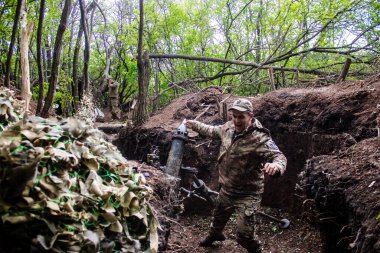 28. Topçu Taburu 'ndan Ukraynalı asker Bakhmut yakınlarındaki ormanın sıfır noktasında bir Rus hedefine 120 mm' lik havan topu atıyor. Rus ve Ukrayna orduları Donbass 'ta çarpışıyor, çatışma yoğun ve savaş şiddetleniyor. Bir...