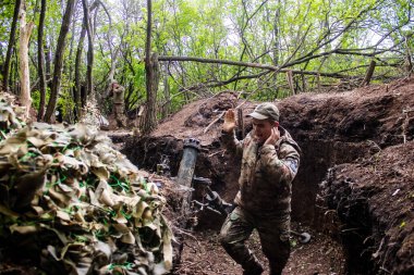 28. Topçu Taburu 'ndan Ukraynalı asker Bakhmut yakınlarındaki ormanın sıfır noktasında bir Rus hedefine 120 mm' lik havan topu atıyor. Rus ve Ukrayna orduları Donbass 'ta çarpışıyor, çatışma yoğun ve savaş şiddetleniyor. Bir...