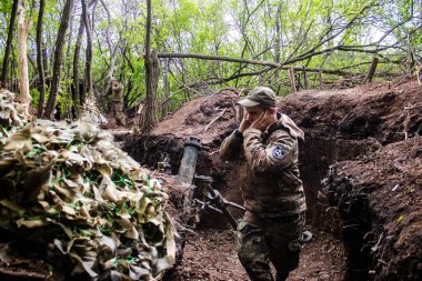 28. Topçu Taburu 'ndan Ukraynalı asker Bakhmut yakınlarındaki ormanın sıfır noktasında bir Rus hedefine 120 mm' lik havan topu atıyor. Rus ve Ukrayna orduları Donbass 'ta çarpışıyor, çatışma yoğun ve savaş şiddetleniyor. Bir...