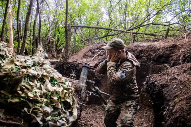 28. Topçu Taburu 'ndan Ukraynalı asker Bakhmut yakınlarındaki ormanın sıfır noktasında bir Rus hedefine 120 mm' lik havan topu atıyor. Rus ve Ukrayna orduları Donbass 'ta çarpışıyor, çatışma yoğun ve savaş şiddetleniyor. Bir...
