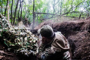 28. Topçu Taburu 'ndan Ukraynalı asker Bakhmut yakınlarındaki ormanın sıfır noktasında bir Rus hedefine 120 mm' lik havan topu atıyor. Rus ve Ukrayna orduları Donbass 'ta çarpışıyor, çatışma yoğun ve savaş şiddetleniyor. Bir...