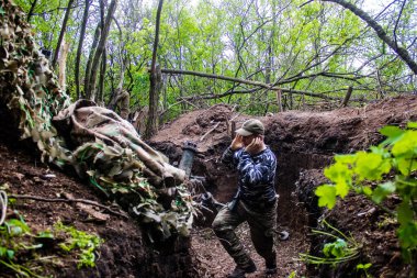 28. Topçu Taburu 'ndan Ukraynalı asker Bakhmut yakınlarındaki ormanın sıfır noktasında bir Rus hedefine 120 mm' lik havan topu atıyor. Rus ve Ukrayna orduları Donbass 'ta çarpışıyor, çatışma yoğun ve savaş şiddetleniyor. Bir...