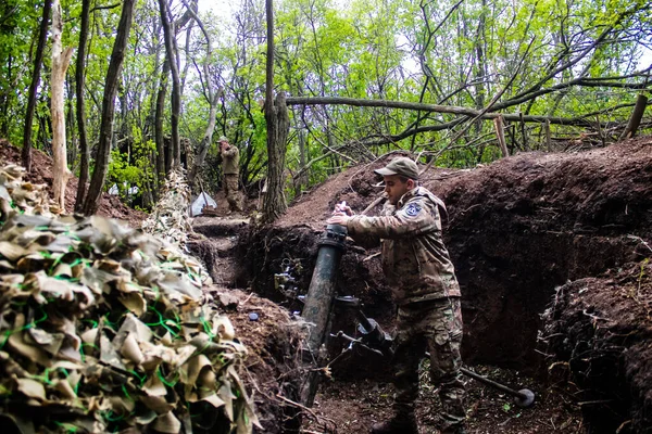 stock image Ukrainian soldier from the 28th Artillery Battalion firing a 120mm mortar at a Russian target in the zero line in the forest near Bakhmut. The Russian and Ukrainian armies clash in the Donbass, the fighting is intense and the battle is raging. With a