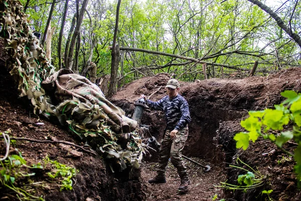 stock image Ukrainian soldier from the 28th Artillery Battalion firing a 120mm mortar at a Russian target in the zero line in the forest near Bakhmut. The Russian and Ukrainian armies clash in the Donbass, the fighting is intense and the battle is raging. With a