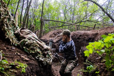 28. Topçu Taburu 'ndan Ukraynalı asker Bakhmut yakınlarındaki ormanın sıfır noktasında bir Rus hedefine 120 mm' lik havan topu atıyor. Rus ve Ukrayna orduları Donbass 'ta çarpışıyor, çatışma yoğun ve savaş şiddetleniyor. Bir...