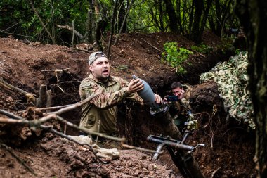 28. Topçu Taburu 'ndan Ukraynalı asker Bakhmut yakınlarındaki ormanın sıfır noktasında bir Rus hedefine 120 mm' lik havan topu atıyor. Rus ve Ukrayna orduları Donbass 'ta çarpışıyor, çatışma yoğun ve savaş şiddetleniyor. Bir...