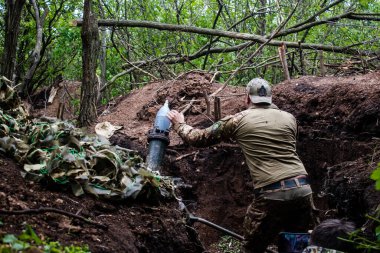 28. Topçu Taburu 'ndan Ukraynalı asker Bakhmut yakınlarındaki ormanın sıfır noktasında bir Rus hedefine 120 mm' lik havan topu atıyor. Rus ve Ukrayna orduları Donbass 'ta çarpışıyor, çatışma yoğun ve savaş şiddetleniyor. Bir...