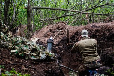 28. Topçu Taburu 'ndan Ukraynalı asker Bakhmut yakınlarındaki ormanın sıfır noktasında bir Rus hedefine 120 mm' lik havan topu atıyor. Rus ve Ukrayna orduları Donbass 'ta çarpışıyor, çatışma yoğun ve savaş şiddetleniyor. Bir...