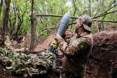 28. Topçu Taburu 'ndan Ukraynalı asker Bakhmut yakınlarındaki ormanın sıfır noktasında bir Rus hedefine 120 mm' lik havan topu atıyor. Rus ve Ukrayna orduları Donbass 'ta çarpışıyor, çatışma yoğun ve savaş şiddetleniyor. Bir...