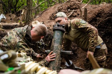 28. Topçu Taburu 'ndan Ukraynalı asker, Bakhmut yakınlarındaki ormanın sıfır hattındaki bir Rus hedefine 120 mm' lik havan topu pozisyonunu ayarlıyor. Rus ve Ukrayna orduları Donbass 'ta çarpışır, savaş şiddetlidir ve savaş şiddetlidir.