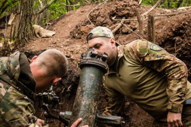 28. Topçu Taburu 'ndan Ukraynalı asker, Bakhmut yakınlarındaki ormanın sıfır hattındaki bir Rus hedefine 120 mm' lik havan topu pozisyonunu ayarlıyor. Rus ve Ukrayna orduları Donbass 'ta çarpışır, savaş şiddetlidir ve savaş şiddetlidir.