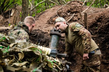 28. Topçu Taburu 'ndan Ukraynalı asker, Bakhmut yakınlarındaki ormanın sıfır hattındaki bir Rus hedefine 120 mm' lik havan topu pozisyonunu ayarlıyor. Rus ve Ukrayna orduları Donbass 'ta çarpışır, savaş şiddetlidir ve savaş şiddetlidir.