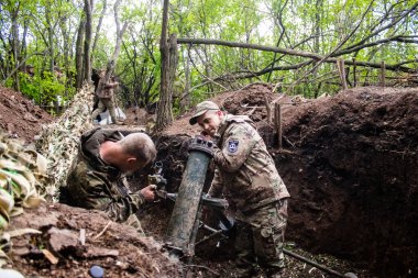 28. Topçu Taburu 'ndan Ukraynalı asker, Bakhmut yakınlarındaki ormanın sıfır hattındaki bir Rus hedefine 120 mm' lik havan topu pozisyonunu ayarlıyor. Rus ve Ukrayna orduları Donbass 'ta çarpışır, savaş şiddetlidir ve savaş şiddetlidir.