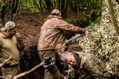 28. Topçu Taburu 'ndan Ukraynalı asker, Bakhmut yakınlarındaki ormanın sıfır hattındaki bir Rus hedefine 120 mm' lik havan topu pozisyonunu ayarlıyor. Rus ve Ukrayna orduları Donbass 'ta çarpışır, savaş şiddetlidir ve savaş şiddetlidir.