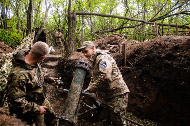 28. Topçu Taburu 'ndan Ukraynalı asker, Bakhmut yakınlarındaki ormanın sıfır hattındaki bir Rus hedefine 120 mm' lik havan topu pozisyonunu ayarlıyor. Rus ve Ukrayna orduları Donbass 'ta çarpışır, savaş şiddetlidir ve savaş şiddetlidir.