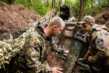 28. Topçu Taburu 'ndan Ukraynalı asker, Bakhmut yakınlarındaki ormanın sıfır hattındaki bir Rus hedefine 120 mm' lik havan topu pozisyonunu ayarlıyor. Rus ve Ukrayna orduları Donbass 'ta çarpışır, savaş şiddetlidir ve savaş şiddetlidir.