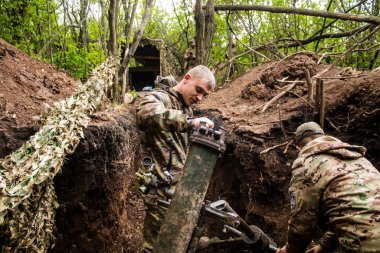 28. Topçu Taburu 'ndan Ukraynalı asker, Bakhmut yakınlarındaki ormanın sıfır hattındaki bir Rus hedefine 120 mm' lik havan topu pozisyonunu ayarlıyor. Rus ve Ukrayna orduları Donbass 'ta çarpışır, savaş şiddetlidir ve savaş şiddetlidir.