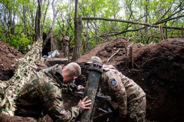 28. Topçu Taburu 'ndan Ukraynalı asker, Bakhmut yakınlarındaki ormanın sıfır hattındaki bir Rus hedefine 120 mm' lik havan topu pozisyonunu ayarlıyor. Rus ve Ukrayna orduları Donbass 'ta çarpışır, savaş şiddetlidir ve savaş şiddetlidir.