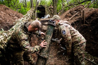 28. Topçu Taburu 'ndan Ukraynalı asker, Bakhmut yakınlarındaki ormanın sıfır hattındaki bir Rus hedefine 120 mm' lik havan topu pozisyonunu ayarlıyor. Rus ve Ukrayna orduları Donbass 'ta çarpışır, savaş şiddetlidir ve savaş şiddetlidir.