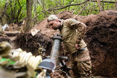28. Topçu Taburu 'ndan Ukraynalı asker, Bakhmut yakınlarındaki ormanın sıfır hattındaki bir Rus hedefine 120 mm' lik havan topu pozisyonunu ayarlıyor. Rus ve Ukrayna orduları Donbass 'ta çarpışır, savaş şiddetlidir ve savaş şiddetlidir.