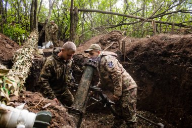 28. Topçu Taburu 'ndan Ukraynalı asker, Bakhmut yakınlarındaki ormanın sıfır hattındaki bir Rus hedefine 120 mm' lik havan topu pozisyonunu ayarlıyor. Rus ve Ukrayna orduları Donbass 'ta çarpışır, savaş şiddetlidir ve savaş şiddetlidir.