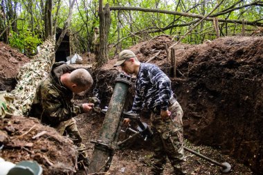 28. Topçu Taburu 'ndan Ukraynalı asker, Bakhmut yakınlarındaki ormanın sıfır hattındaki bir Rus hedefine 120 mm' lik havan topu pozisyonunu ayarlıyor. Rus ve Ukrayna orduları Donbass 'ta çarpışır, savaş şiddetlidir ve savaş şiddetlidir.