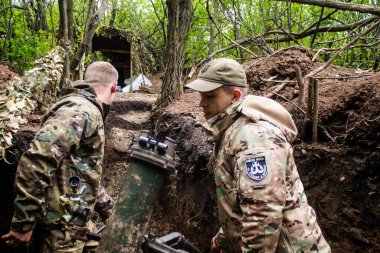 28. Topçu Taburu 'ndan Ukraynalı asker, Bakhmut yakınlarındaki ormanın sıfır hattındaki bir Rus hedefine 120 mm' lik havan topu pozisyonunu ayarlıyor. Rus ve Ukrayna orduları Donbass 'ta çarpışır, savaş şiddetlidir ve savaş şiddetlidir.