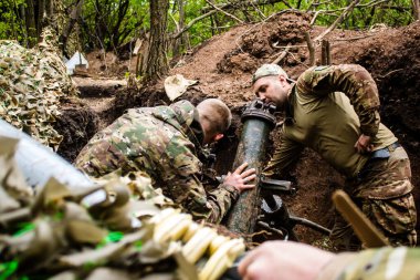 28. Topçu Taburu 'ndan Ukraynalı asker, Bakhmut yakınlarındaki ormanın sıfır hattındaki bir Rus hedefine 120 mm' lik havan topu pozisyonunu ayarlıyor. Rus ve Ukrayna orduları Donbass 'ta çarpışır, savaş şiddetlidir ve savaş şiddetlidir.