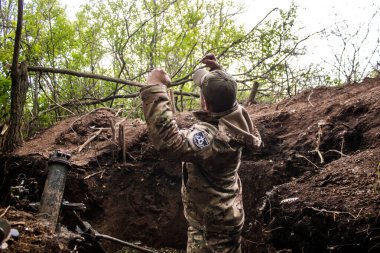 28. Topçu Taburu 'ndan Ukraynalı asker, Bakhmut yakınlarındaki ormanın sıfır hattındaki bir Rus hedefine 120 mm' lik havan topu atıyor. Rus ve Ukrayna orduları Donbass 'ta çarpışıyor, çatışma yoğun ve savaş şiddetleniyor.. 