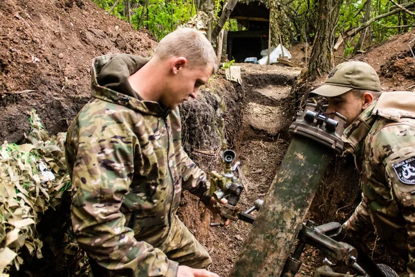 stock image Ukrainian soldier from the 28th Artillery Battalion adjusting the position of a 120mm mortar on a Russian target on the zero line in the forest near Bakhmut. The Russian and Ukrainian armies clash in the Donbass, the fighting is intense and the battl