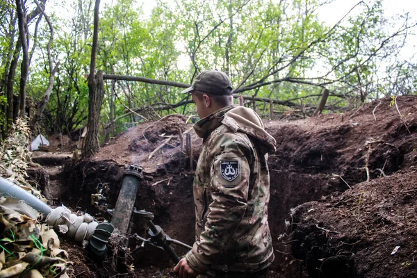 stock image Ukrainian soldier from the 28th Artillery Battalion posing front a 120mm mortar at a Russian target in the zero line in the forest near Bakhmut. The Russian and Ukrainian armies clash in the Donbass, the fighting is intense and the battle is raging. 