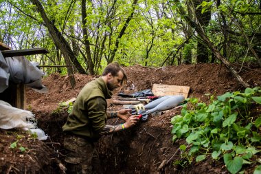 28. Topçu Taburu 'nun Ukraynalı askeri Bakhmut yakınlarındaki ormanın sıfır hattındaki bir Rus hedefine 120 mm' lik bir havan topu hazırlıyor. Rus ve Ukrayna orduları Donbass 'ta çarpışır, savaş şiddetlidir ve savaş...