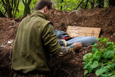 28. Topçu Taburu 'nun Ukraynalı askeri Bakhmut yakınlarındaki ormanın sıfır hattındaki bir Rus hedefine 120 mm' lik bir havan topu hazırlıyor. Rus ve Ukrayna orduları Donbass 'ta çarpışır, savaş şiddetlidir ve savaş...