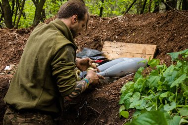 28. Topçu Taburu 'nun Ukraynalı askeri Bakhmut yakınlarındaki ormanın sıfır hattındaki bir Rus hedefine 120 mm' lik bir havan topu hazırlıyor. Rus ve Ukrayna orduları Donbass 'ta çarpışır, savaş şiddetlidir ve savaş...