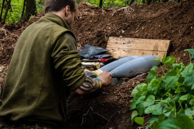 28. Topçu Taburu 'nun Ukraynalı askeri Bakhmut yakınlarındaki ormanın sıfır hattındaki bir Rus hedefine 120 mm' lik bir havan topu hazırlıyor. Rus ve Ukrayna orduları Donbass 'ta çarpışır, savaş şiddetlidir ve savaş...
