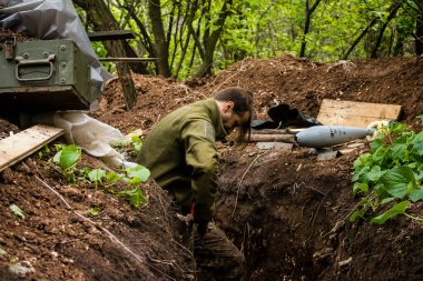 28. Topçu Taburu 'nun Ukraynalı askeri Bakhmut yakınlarındaki ormanın sıfır hattındaki bir Rus hedefine 120 mm' lik bir havan topu hazırlıyor. Rus ve Ukrayna orduları Donbass 'ta çarpışır, savaş şiddetlidir ve savaş...