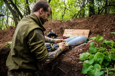 28. Topçu Taburu 'nun Ukraynalı askeri Bakhmut yakınlarındaki ormanın sıfır hattındaki bir Rus hedefine 120 mm' lik bir havan topu hazırlıyor. Rus ve Ukrayna orduları Donbass 'ta çarpışır, savaş şiddetlidir ve savaş...